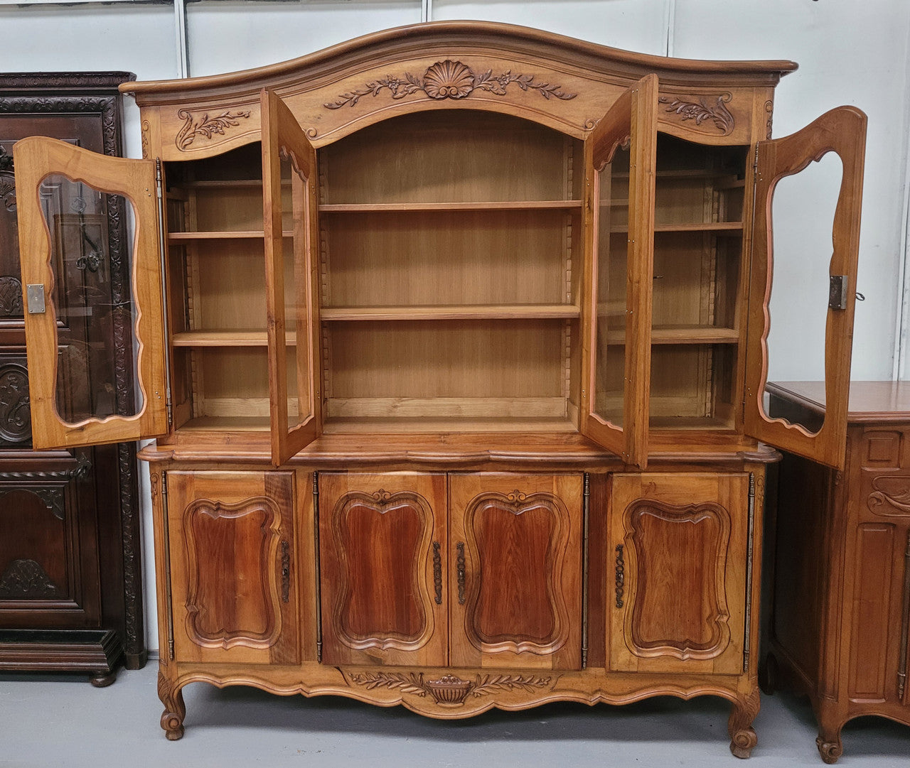 Magnificent French Walnut two-body four door display cabinet. Heaps of storage space with four glass doors at the top with shelves and four solid doors below also with shelving. It has been sourced from France and comes with a key for each door and all are lockable. In good original detailed condition.