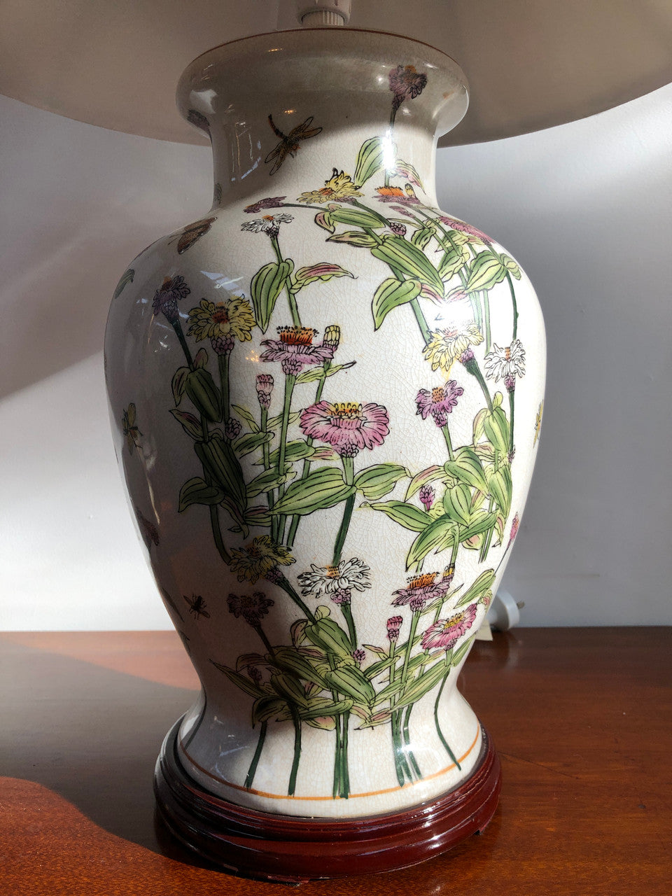 Contemporary ceramic lamp base decorated with daises & butterflies on a wooden base with shade.