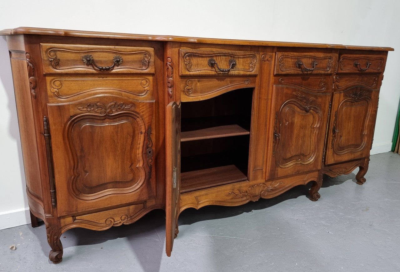 A Beautifully carved French Walnut Louis XV style four door sideboard. Plenty of storage space with four doors as well as four drawers. It is in good original detailed condition.
