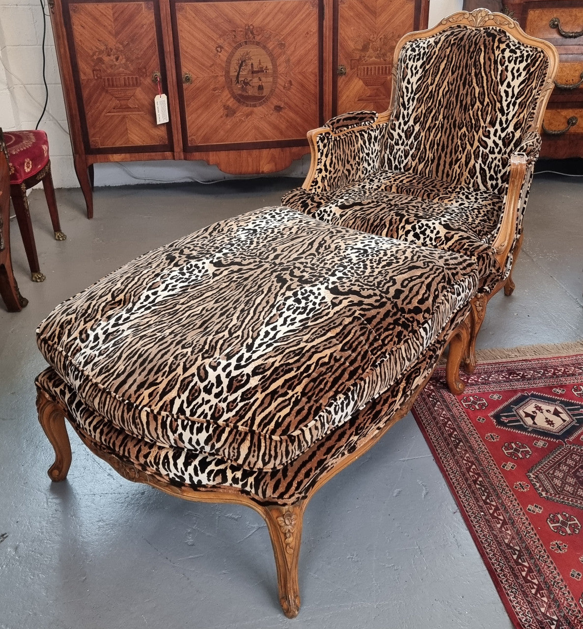A French Louis XV style armchair with leopard print upholstery and with matched footstool. Fabric is in good original used condition. Please view photos as they help form part of the description.