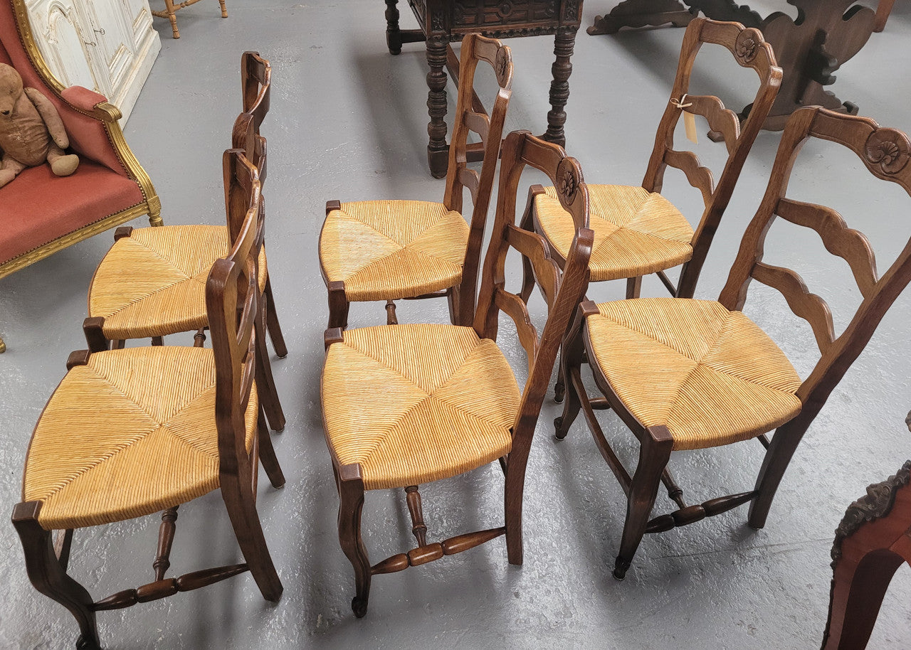 Set of six Louis XV style French Oak rush seat dining chairs. They are in good original detailed condition.