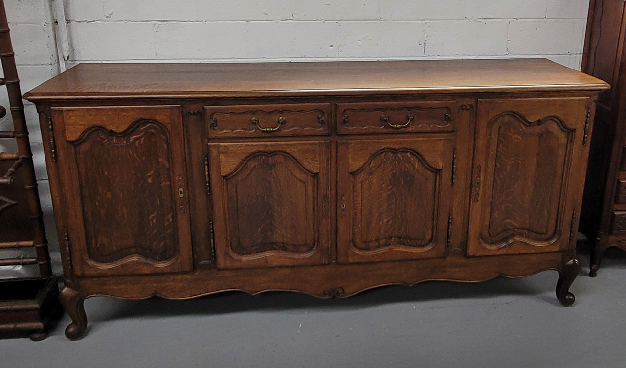 Louis XV style French Oak sideboard consisting of four doors and two drawers. It is in good restored condition.