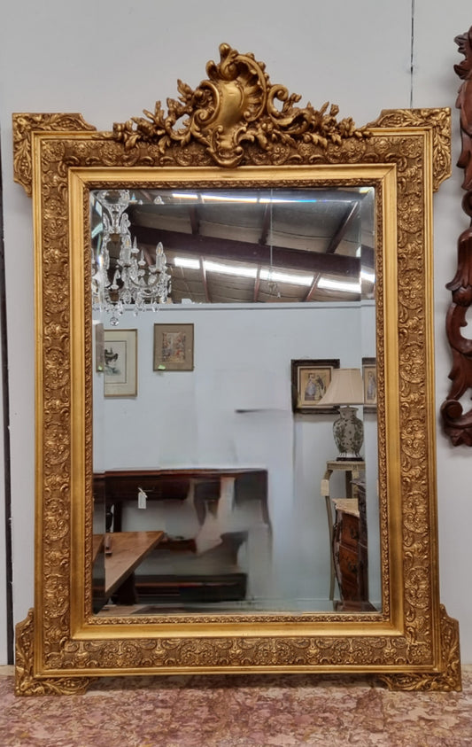 French ornate gilt decorated and floral bevelled mirror. It has been sourced from France and it is in good original condition.