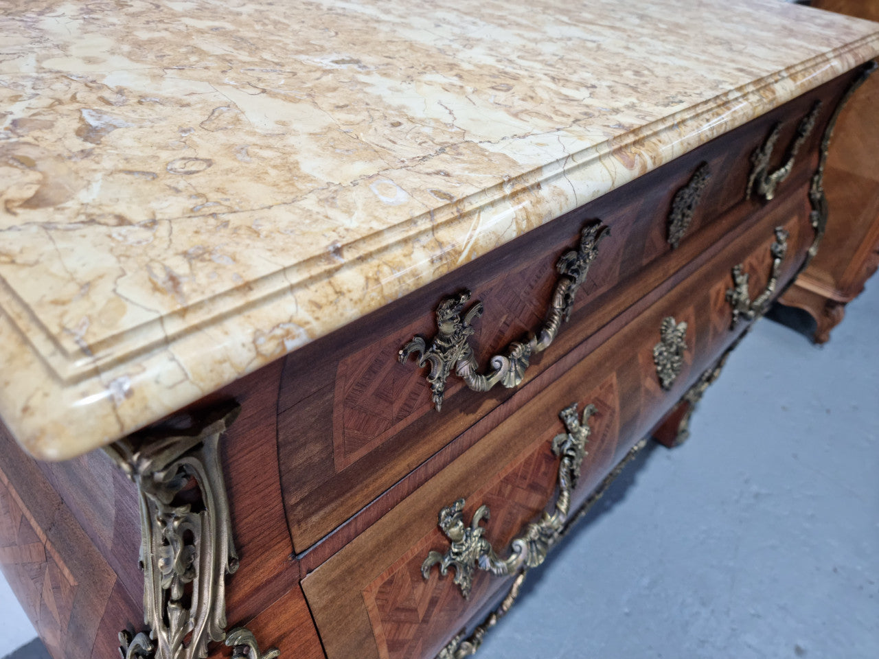 A beautifully inlaid parquetry three drawer commode with a lovely marble top, and decorative ormolu mounts. In good original detailed condition. Circa 1930