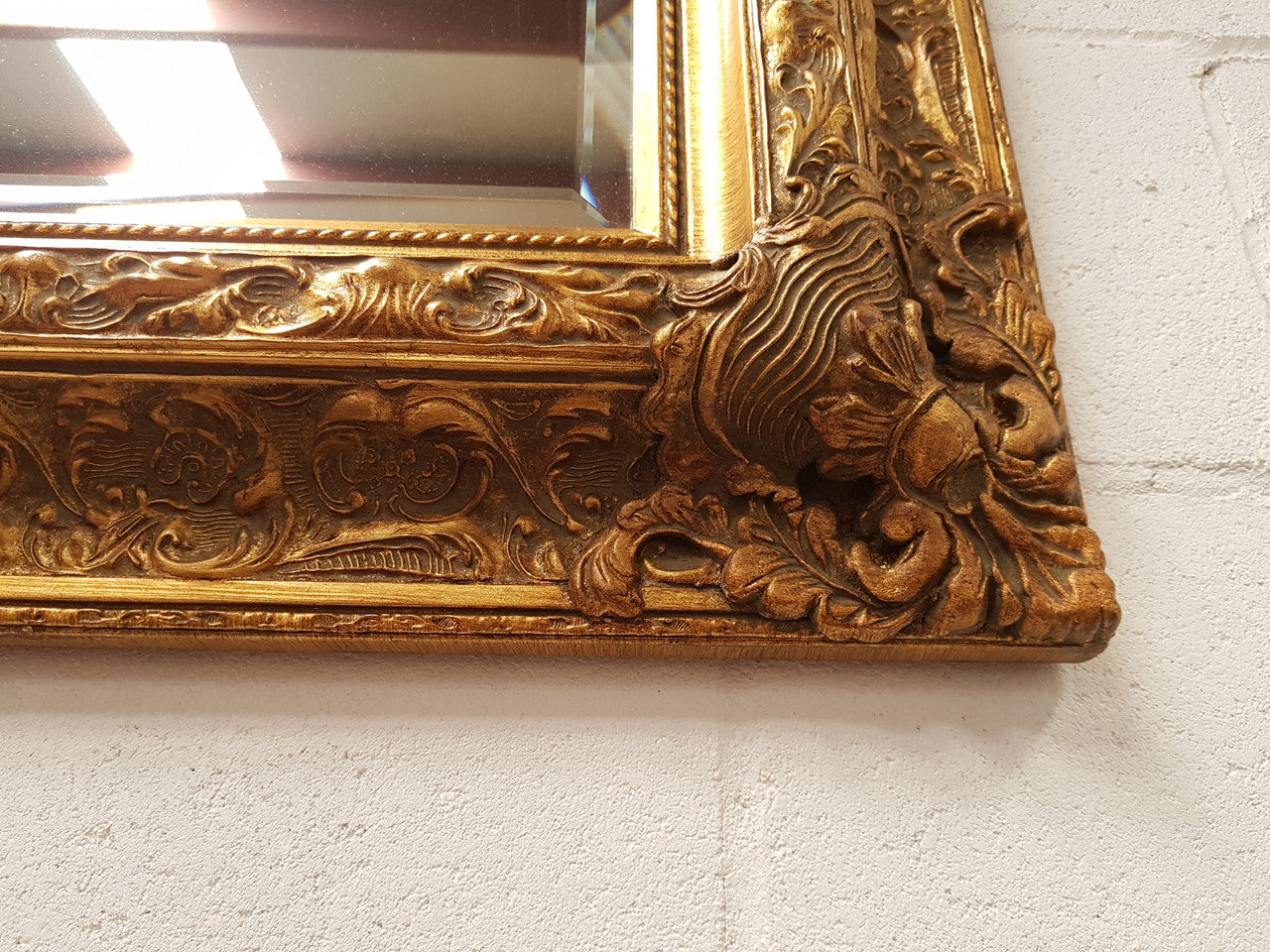 A beautiful French style reproduction heavily carved ornate gilt wall mirror in good original condition.