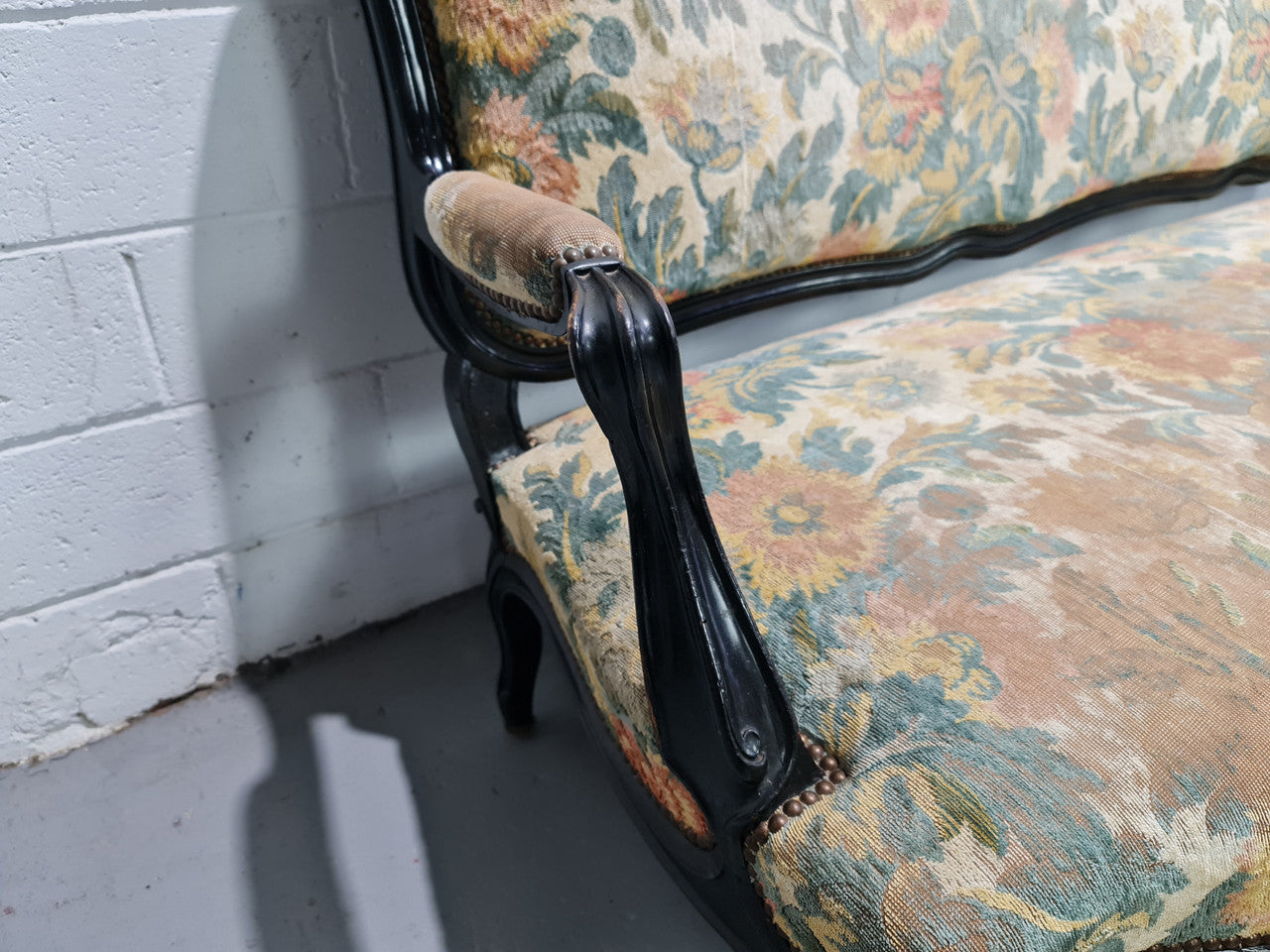 A Substantial Antique 19th Century Louis XV style ebonized serpentine front settee. The fabric is in used condition showing use and could be used as is or reupholster.