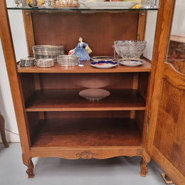 French Oak Louis XV Style Vitrine with two fixed glass shelves at the top and two fixed wooden shelves at the base for added storage. It has been sourced from France and in good original detailed condition.