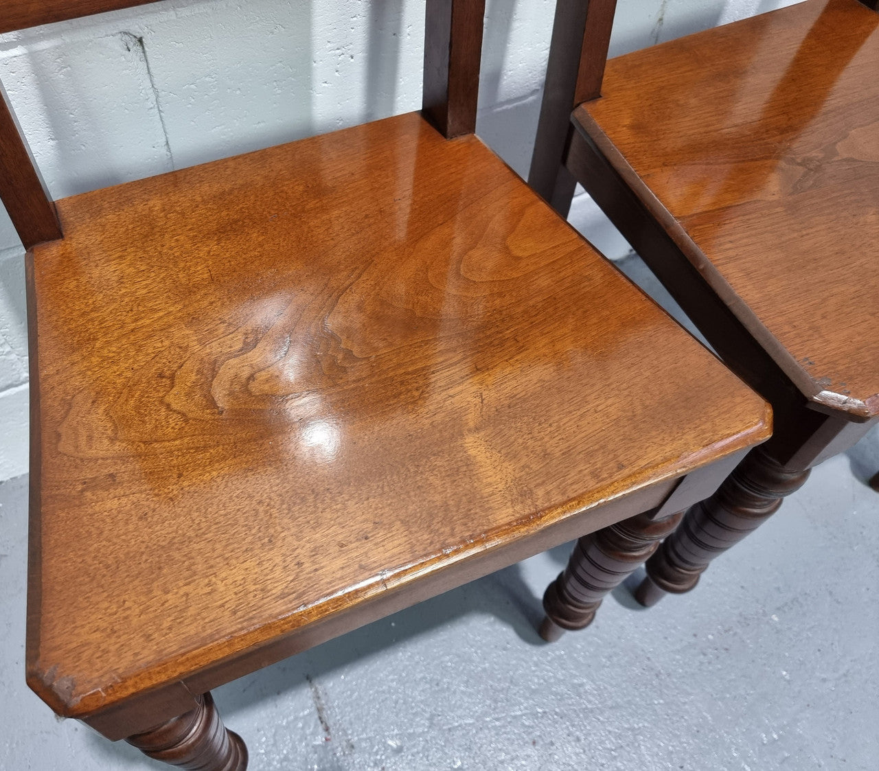 Pair of Edwardian Mahogany hall chairs with original tile in back. They are in very good original detailed condition.
