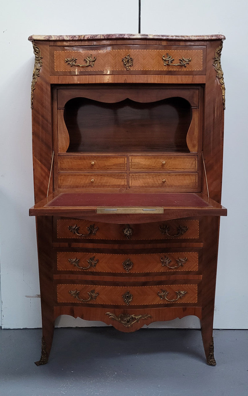 Walnut Louis XV style marble top abbattant with beautiful parquetry inlay and ormolu mounts. It has plenty of storage space with four large drawers and four smaller internal drawers. Beautiful drop down desk with a leather insert. In very good original detailed condition.