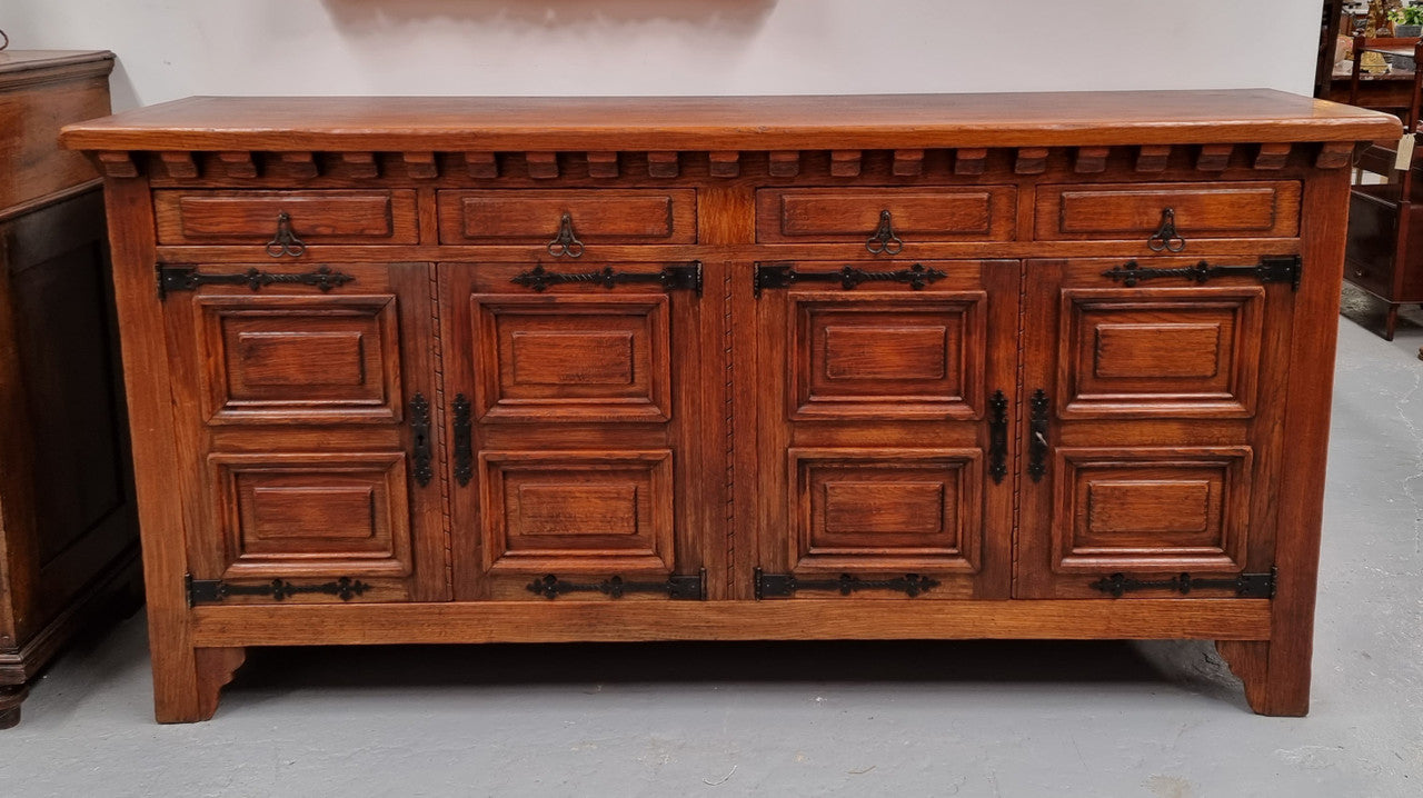 Large Rustic Oak Spanish style four door buffet with plenty of storage and fabulous hardware. It is in good original detailed condition.
