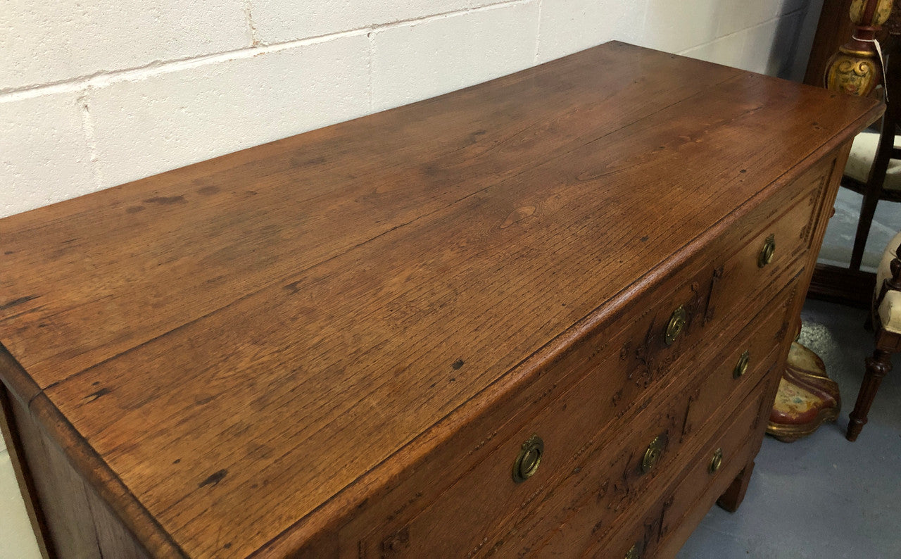 Lovely carved early 19th Century French Oak commode. There are three drawers with decorative drawer pulls and is in good original detailed condition.