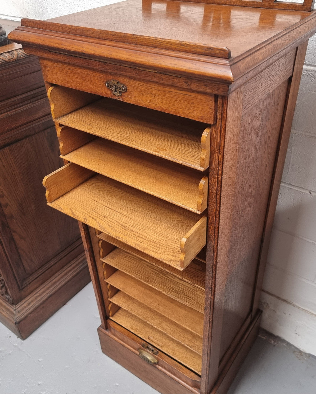 Antique Edwardian roll top Tambour file cabinet desk. This practical antique tambour front filing cabinet dates around 1900 in the Edwardian period and is constructed from Oak. This antique cabinet has an adjustable writing slope, above a tambour front with key and working lock. It has been sourced locally and is in good original detailed condition.
