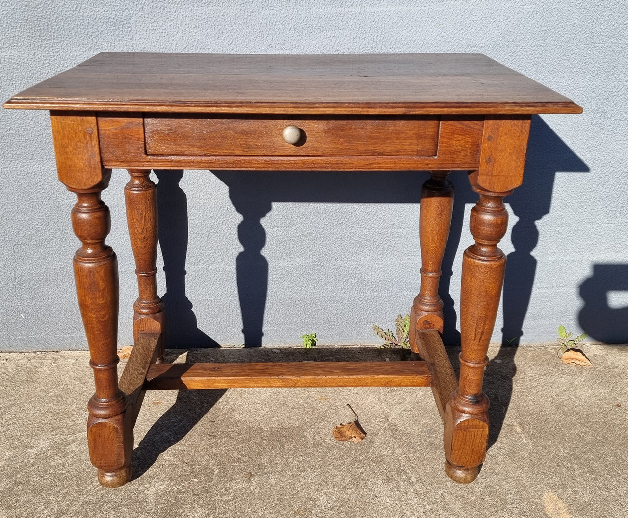 Rustic French Oak side table or desk with single drawer and turned legs. In good original detailed condition.
