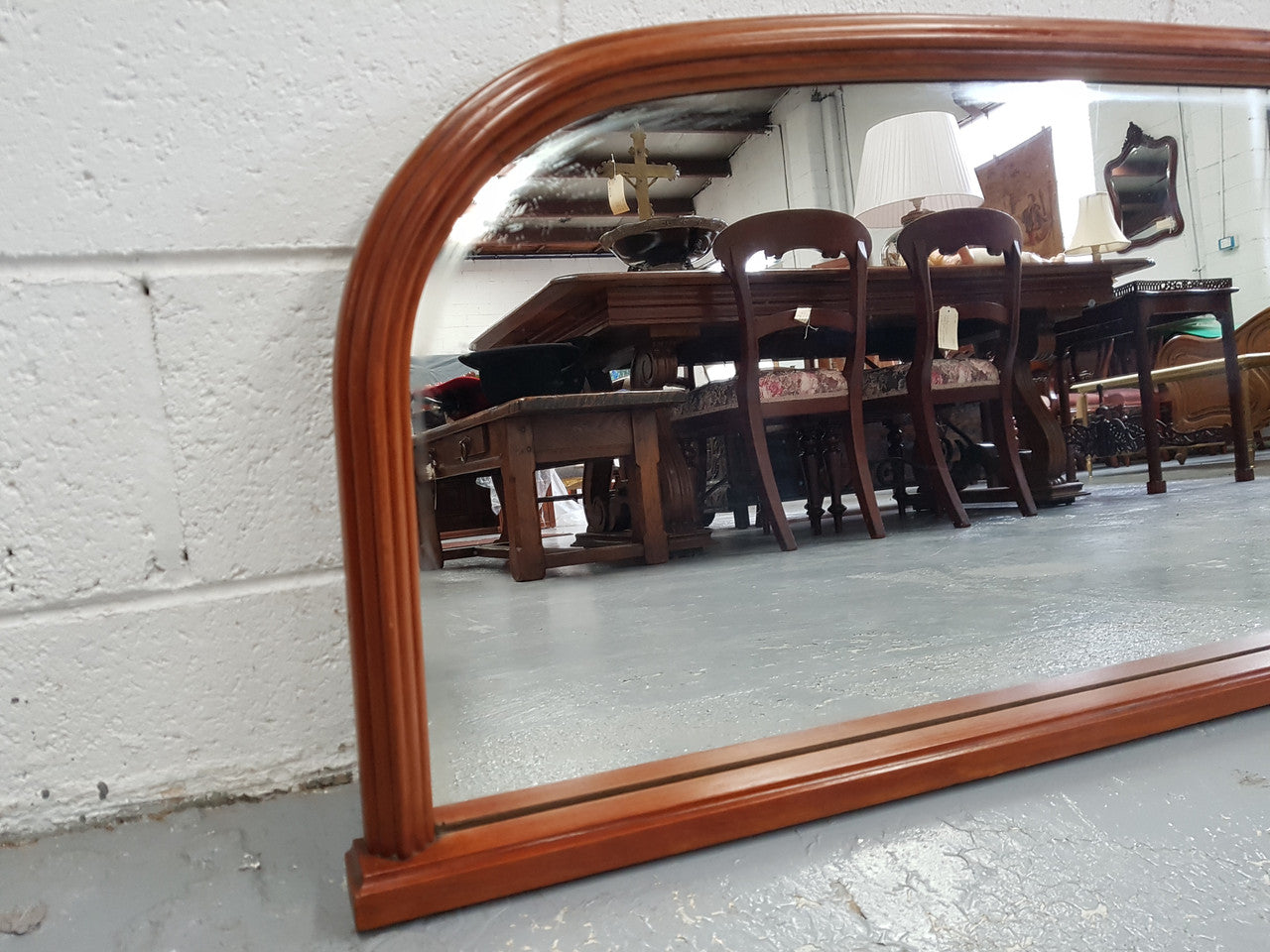 Art Deco mahogany mirror of long and narrow portions. In good original condition and retaining it's original mirror.