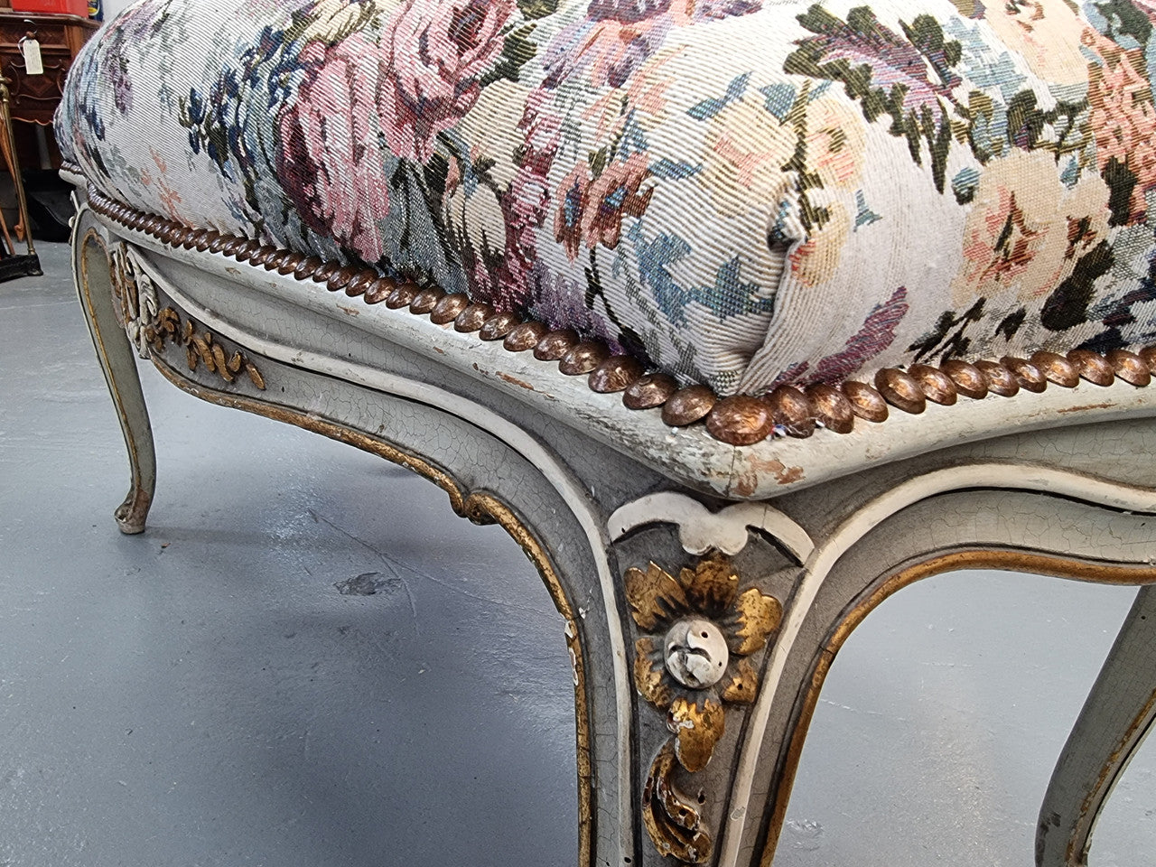 Antique painted Louis XV style upholstered stool. It has lovely floral upholstery that is in good condition with no tears. It is in good original detailed condition.