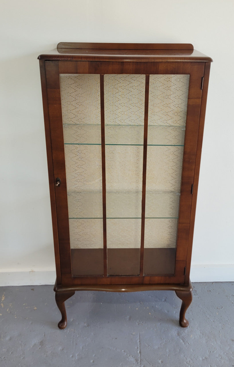Petite single door Walnut display cabinet. Art Deco style with glass display door and two fixed shelves. In original condition.