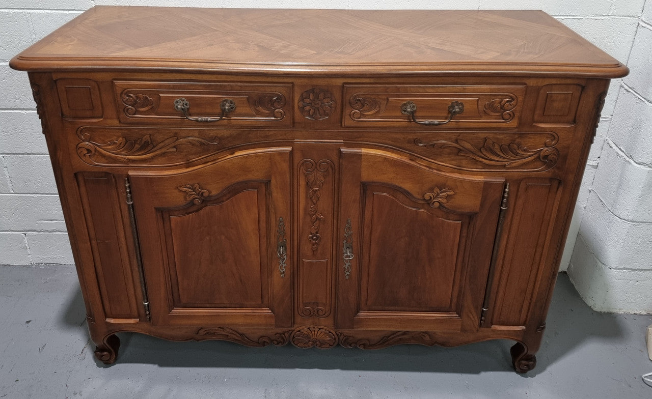 French Walnut two door buffet with parquetry top. It has two drawers and an adjustable shelf. In good original detailed condition and it has been sourced from France.