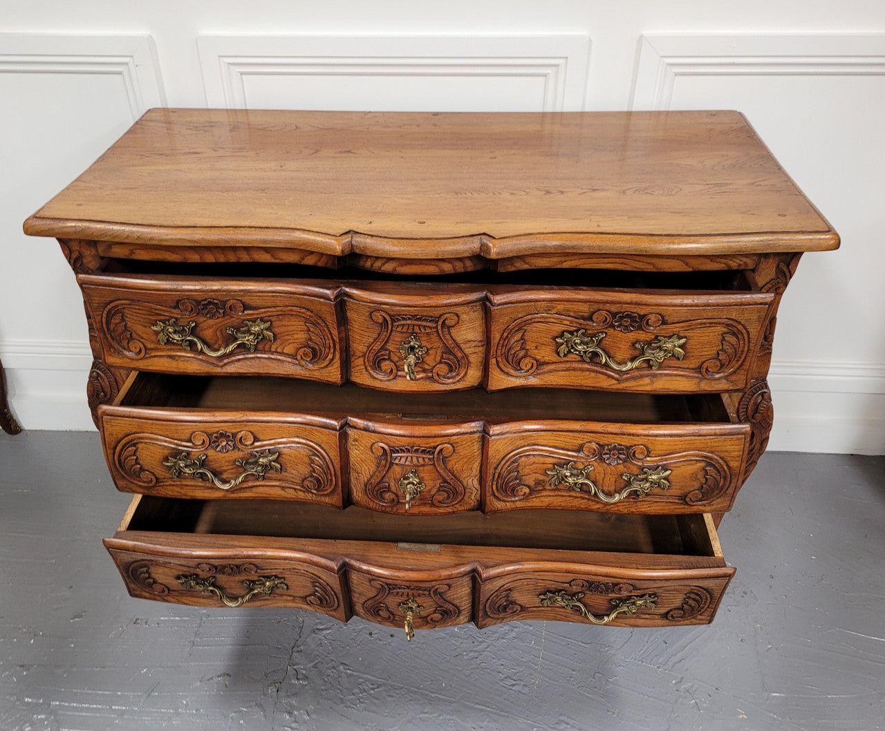 French Antique Louis XIV style Oak wooden top commode. It has a stunning serpentine bombe shape front along with amazing handles and carvings. It comes with three beautiful keys as pictured and comes with working locks. It has been sourced from France and in good original detailed condition.