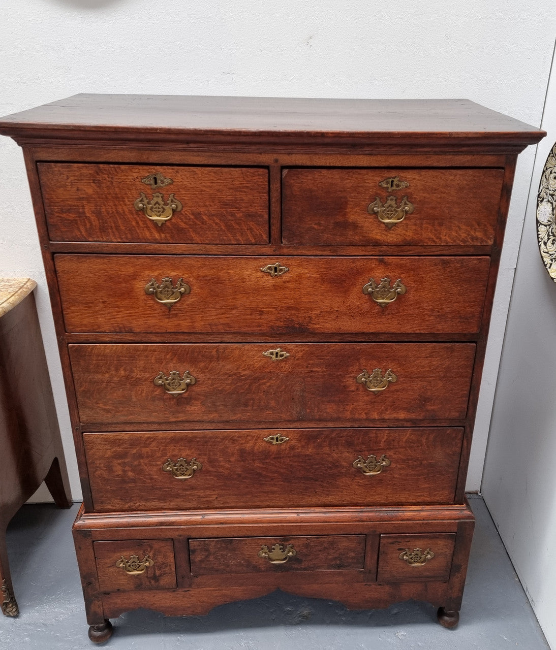Early 19th Century English Oak chest on stand. It has been sourced in France and has plenty of storage space with eight drawers. In good original detailed condition.