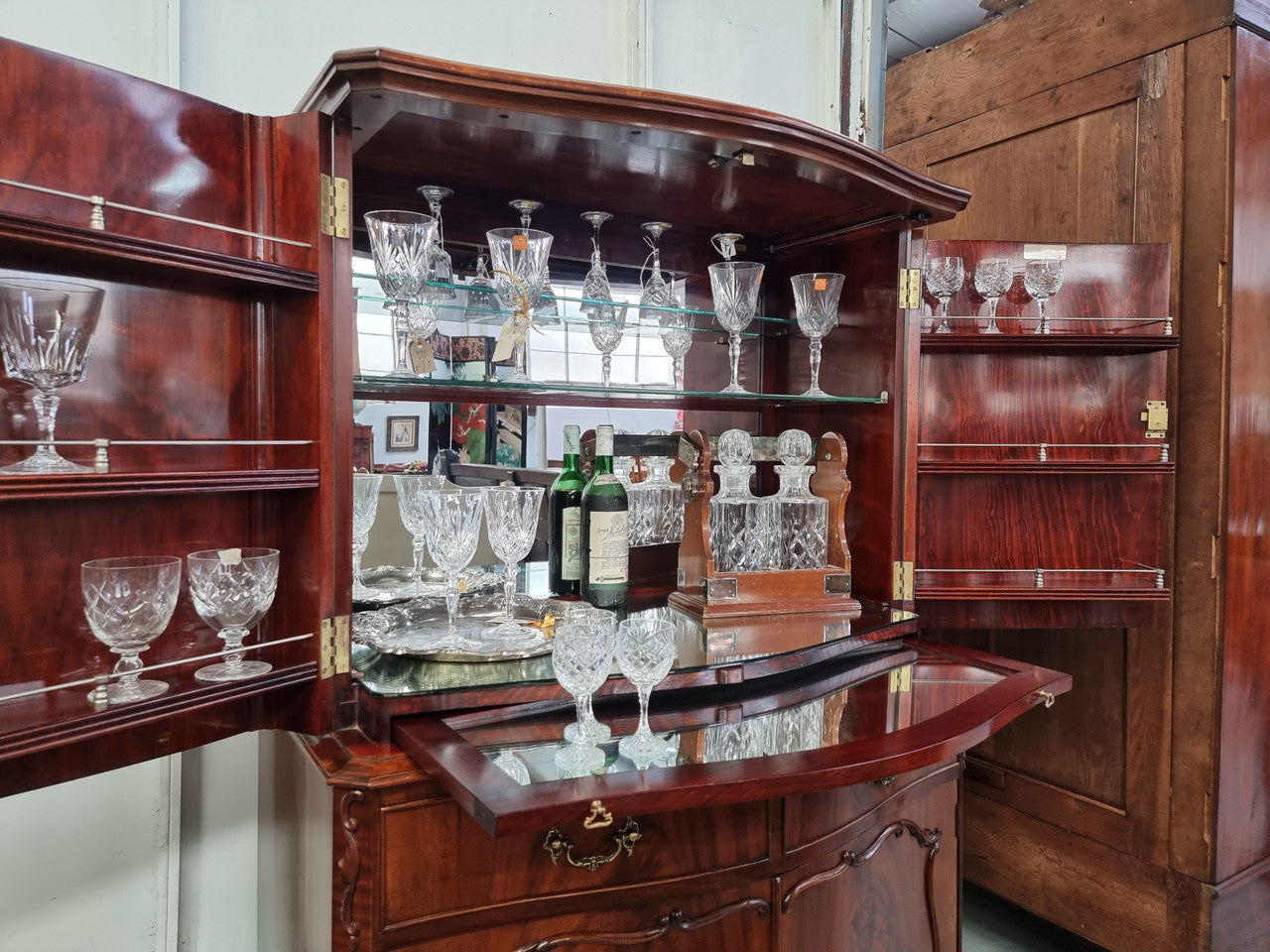 1950’s Chippendale Style Flame Mahogany Four door Bar. The top section has glass shelves and a mirrored pull out tray for storing glasses, decanters & serving etc. It also has a silver presentation plaque to the Mayor of Hawthorn 1958. The bottom section is for storage bottles etc. A stunning and practical piece.