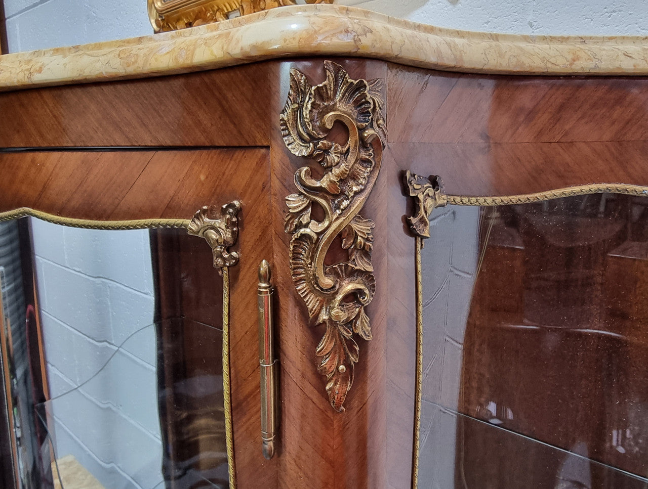 Grand French Walnut Louis XV style marble top vitrine. It has two glass shelfs and one mirrored shelf at the bottom and added storage at bottom. It is in good original detailed condition.