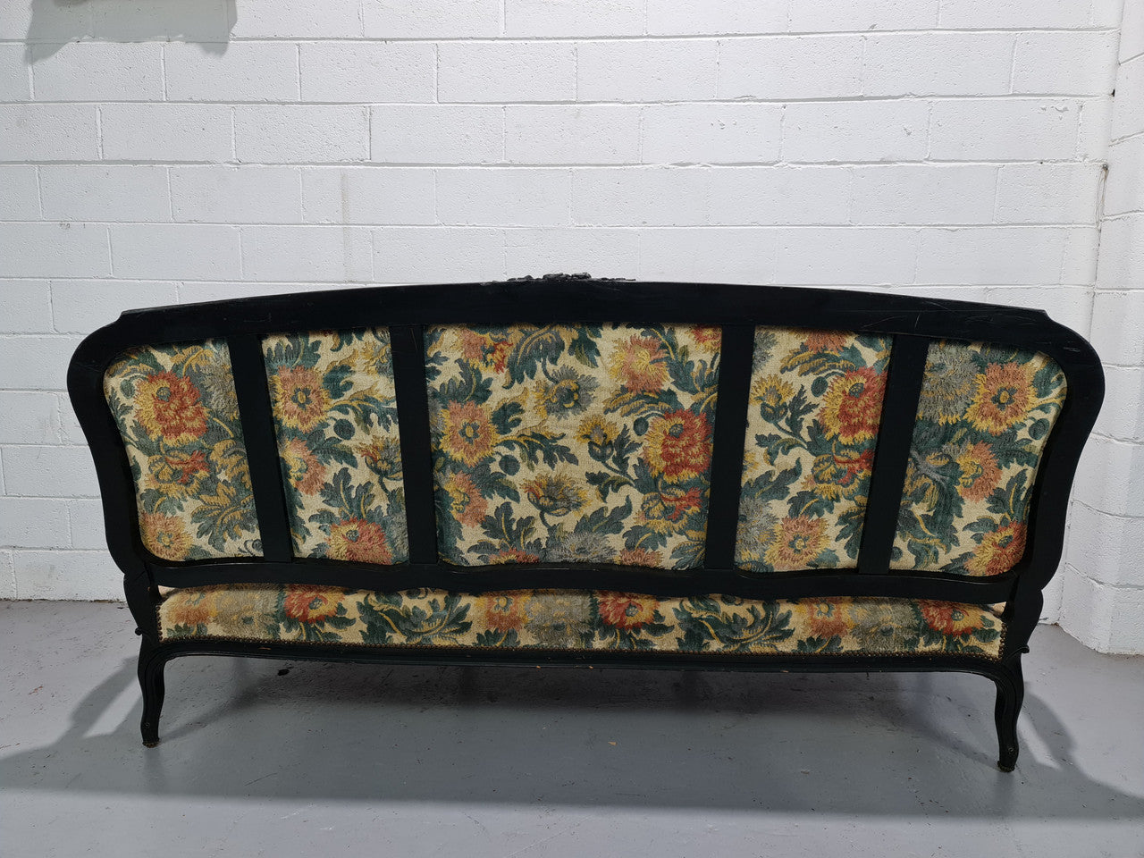 A Substantial Antique 19th Century Louis XV style ebonized serpentine front settee. The fabric is in used condition showing use and could be used as is or reupholster.