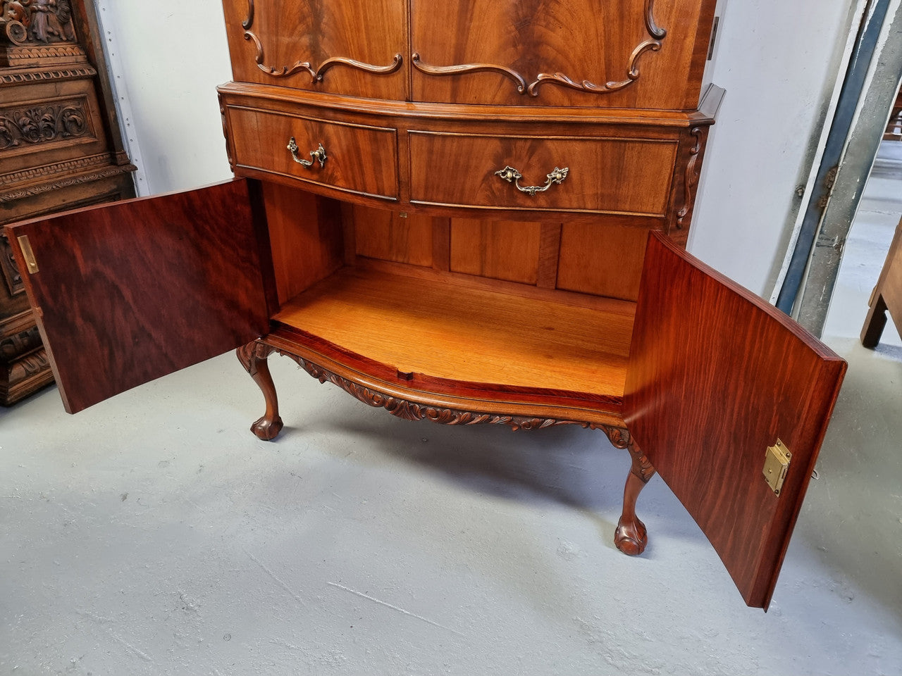 1950’s Chippendale Style Flame Mahogany Four door Bar. The top section has glass shelves and a mirrored pull out tray for storing glasses, decanters & serving etc. It also has a silver presentation plaque to the Mayor of Hawthorn 1958. The bottom section is for storage bottles etc. A stunning and practical piece.