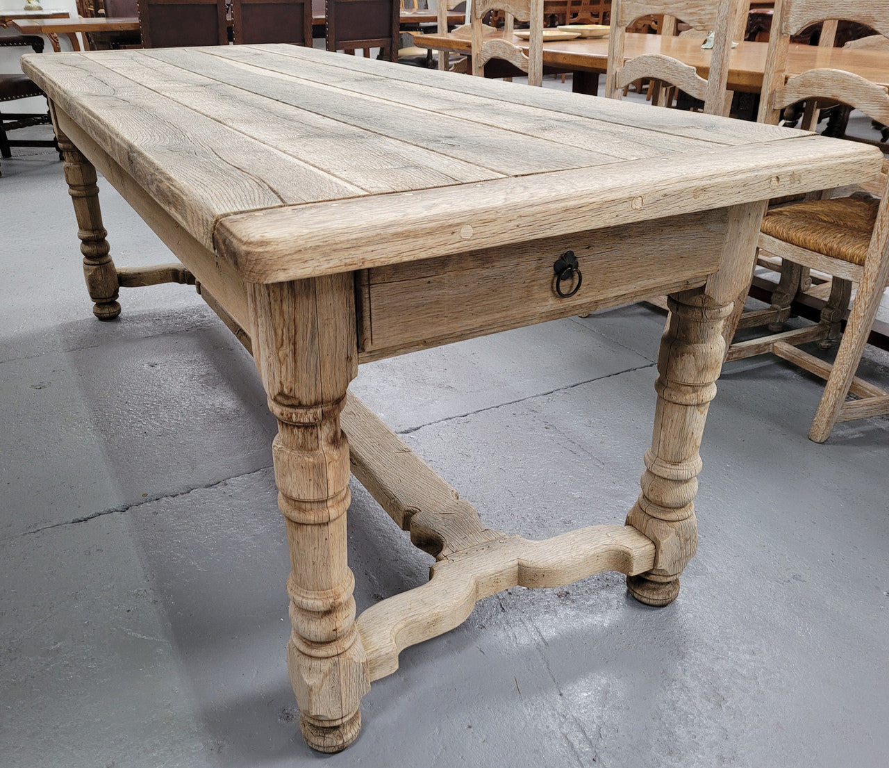 French stripped Oak pedestal stretcher base Farmhouse table with two drawers on either side of table. Features raw wood that could be used as is for a distressed look, or finished and waxed for a more refined look.