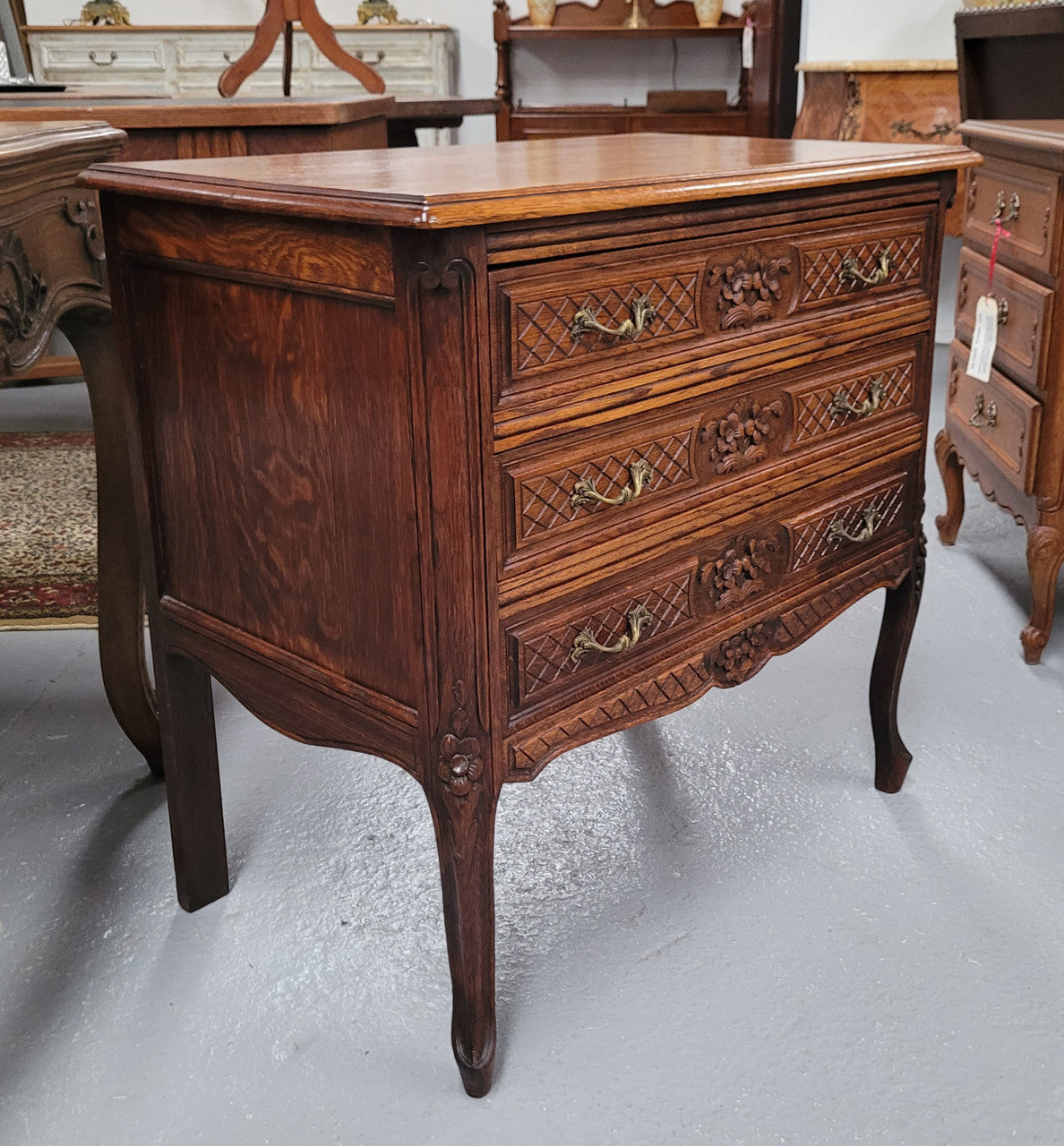 Rustic Louis XV style Oak petite three drawer chest featuring attractive carvings. It has been sourced locally and it is in good original detailed condition.