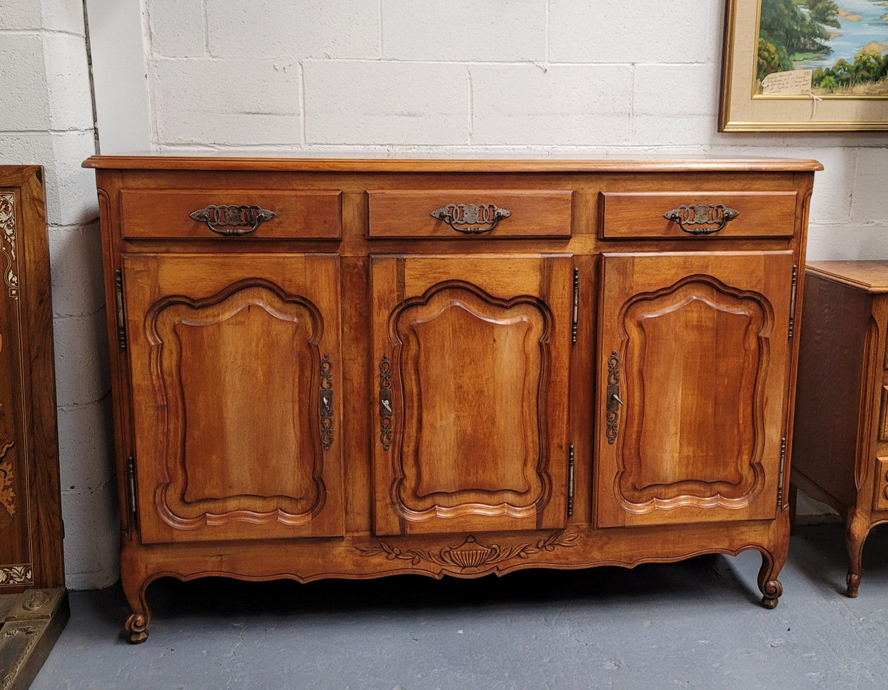 Beautiful French three door three drawer Louis XV style Cherrywood sideboard. It has a total of four adjustable shelves and comes with three keys. It has been sourced from France and is in good original detailed condition.
