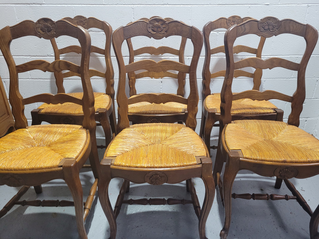 Set of six French Louis 15th style rush seated dining chairs. They are comfortable to sit in and are in original condition.