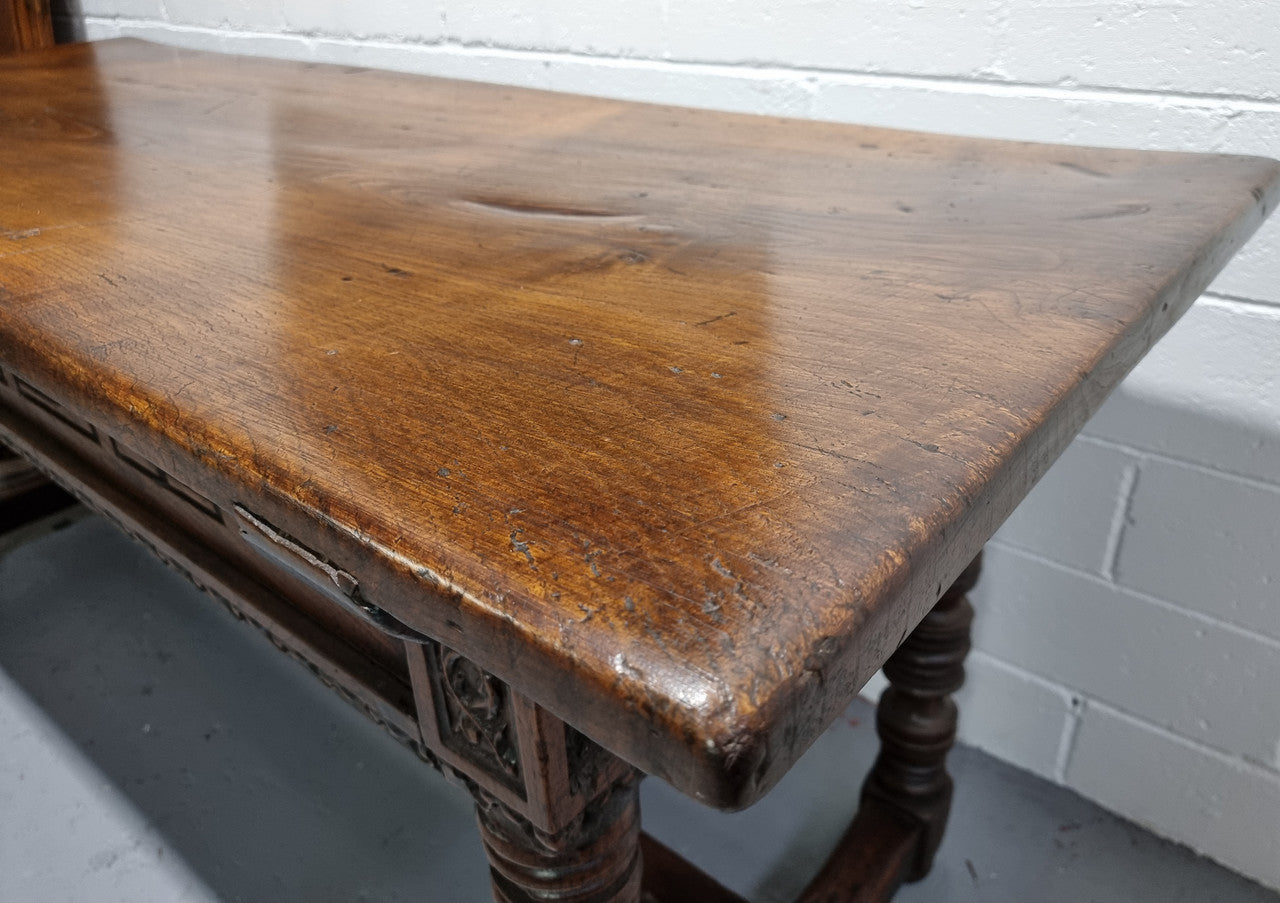 Rare and Charming 17th Century Spanish Walnut serving / side table. It has an incredible one piece walnut top with amazing character and colour. The base displays the original patina aswell as three drawers with carving and remnants of original locks. Superbly turned legs terminating on a stretcher base. Could be used as a large entrance console table, a side table or in a dining area as a serving table. In good original detailed condition especially considering its age.