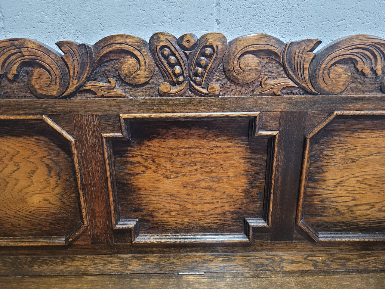 English Oak Tudor style hall seat with lift up top and a storage compartment underneath. It is in good original detailed condition with its original finish.