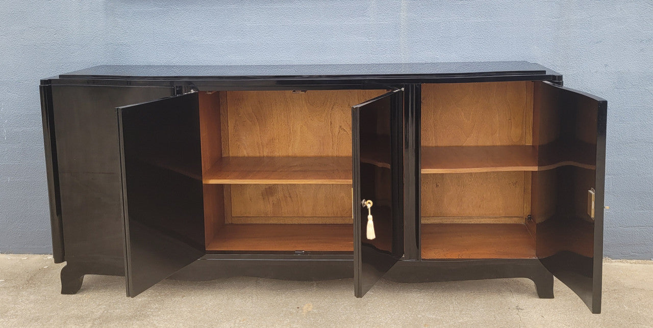 French Art Deco sideboard with a custom black lacquer finish. Beautiful serpent shaped front with four cupboards with working locks and includes to working keys. It is in original condition.