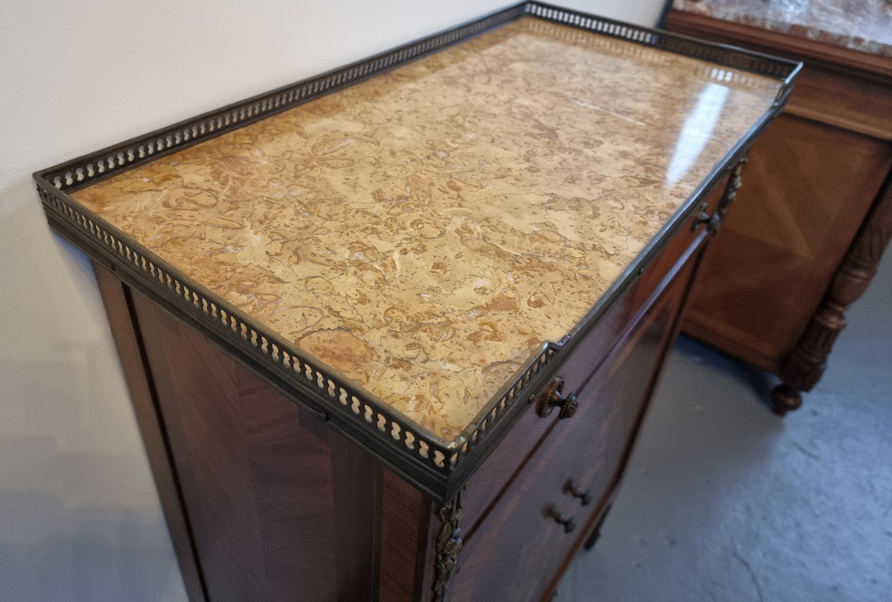 Louis 16th style marquetry inlaid side cabinet with a pierced brass gallery surrounding a marble top. It has two doors open up to storage with one shelf and a drawer above that. In good original detailed condition.