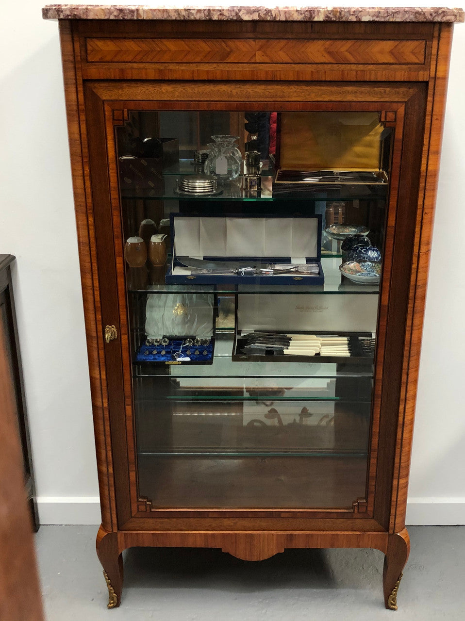 Beautiful French walnut and parquetry inlaid vitrine with lovely bevelled glass and a marble top. It comes with four glass shelves which are adjustable and it is in good original condition.