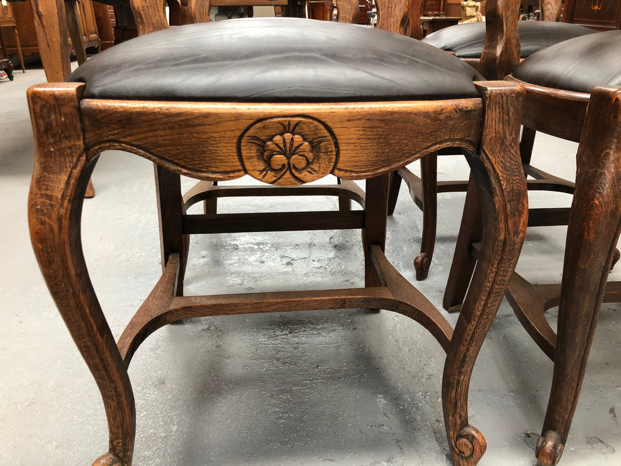 A set of four French Louis XV style, ladder back oak chairs. With finely carved detail and newly upholstered leather look seat. In great original condition. Chairs are comfortable and sturdy for everyday use.