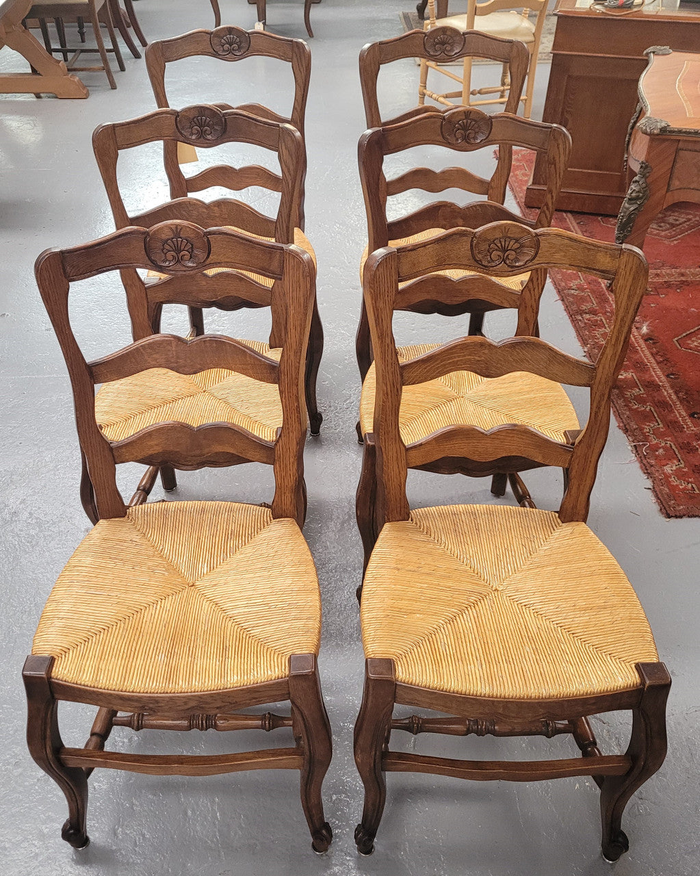 Set of six Louis XV style French Oak rush seat dining chairs. They are in good original detailed condition.