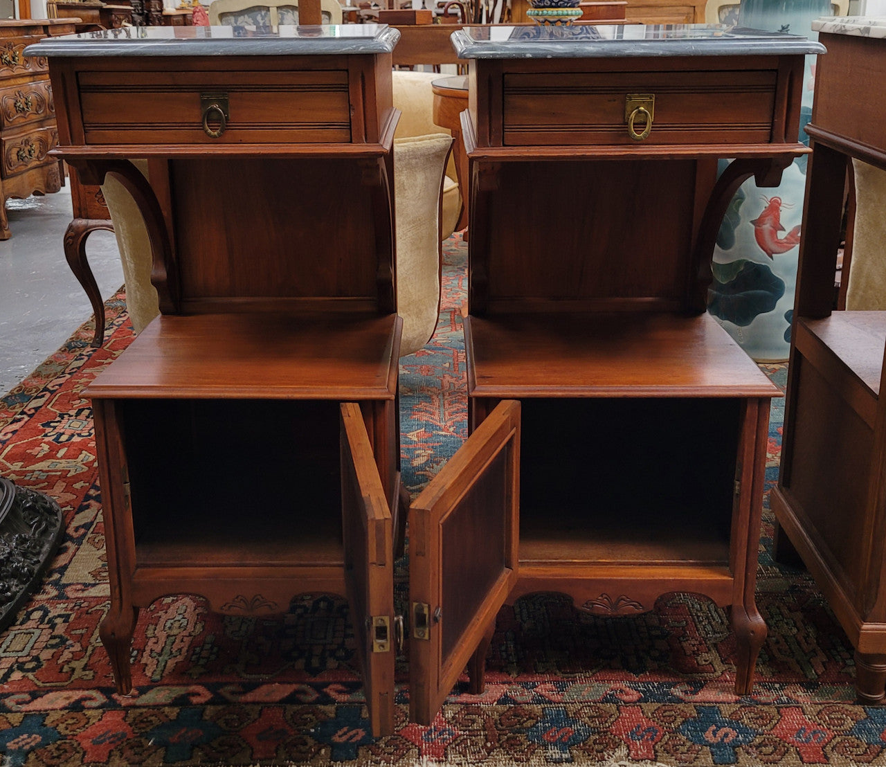 Pair of unusual transitional fruit wood marble top bedside cabinets. They have been sourced from France and are in good original detailed condition.