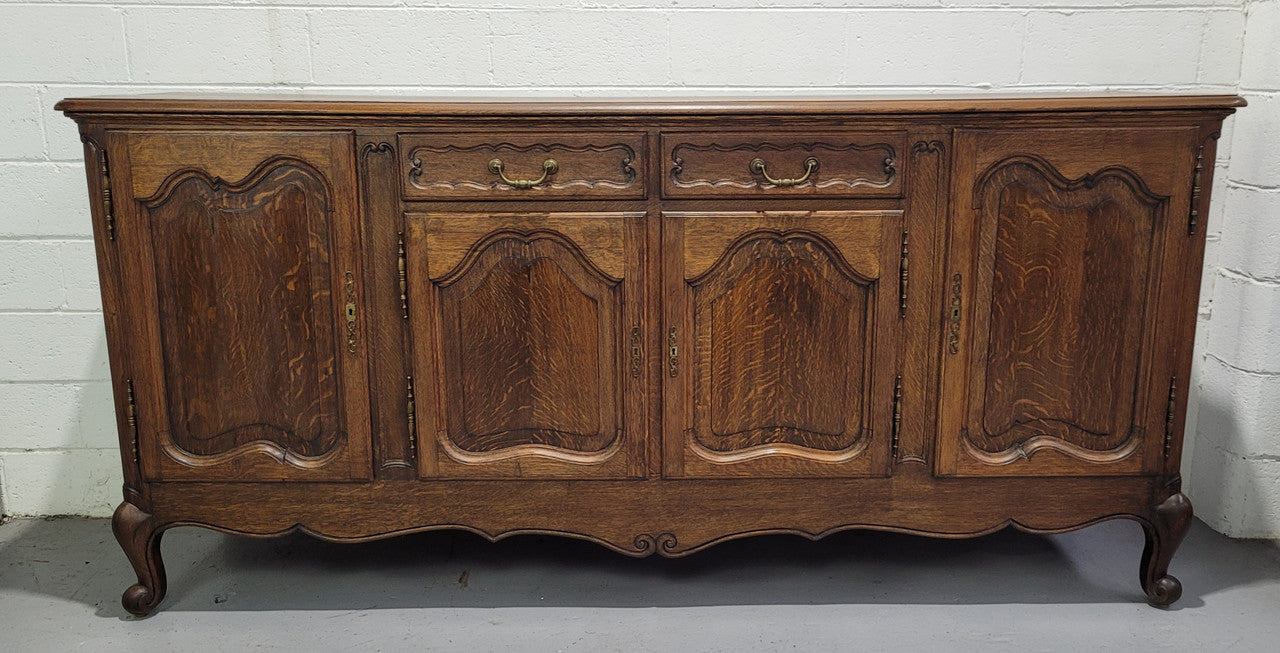 Late 19th Century French carved Oak Louis XV style four drawer sideboard. Plenty of storage space with four cupboards and two drawers. It is in good original detailed condition with all locks functioning with keys.