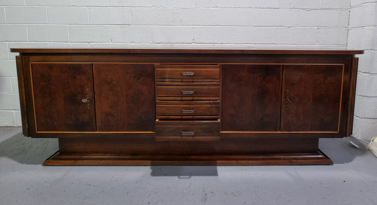 Amazing French Walnut Art deco four door buffet. The doors either side open to a fixed shelf and plenty of added storage with four drawers. In good original detailed condition.