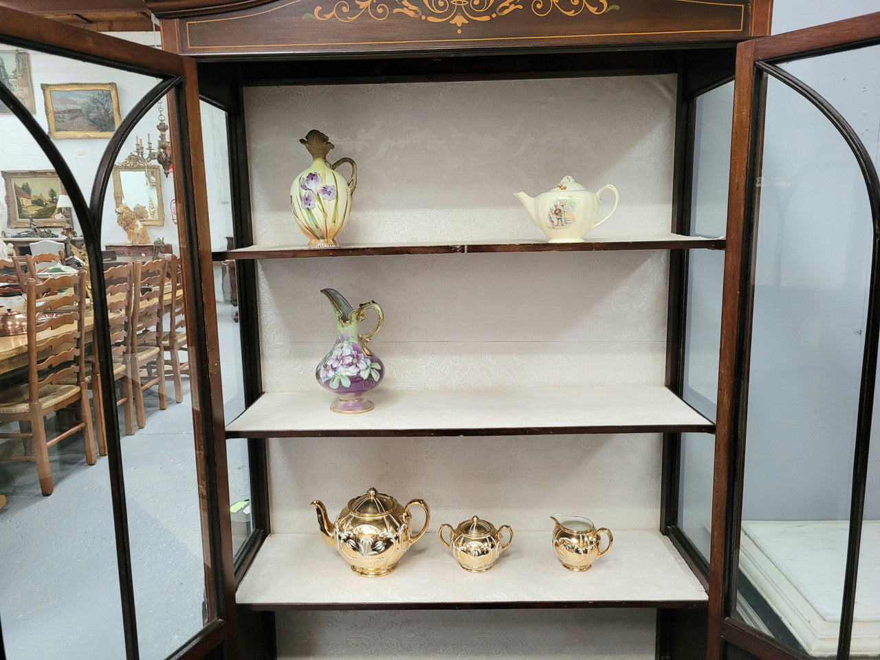 Edwardian Sheraton style display cabinet with hand-painted panels and a good fabric interior. In good original detailed condition.