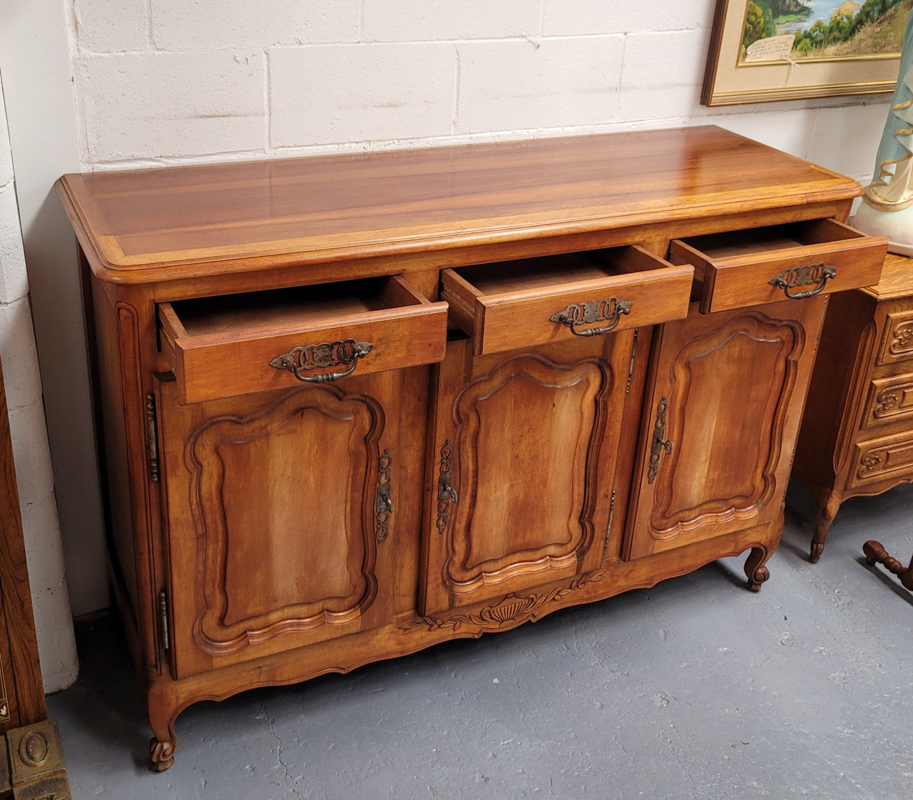 Beautiful French three door three drawer Louis XV style Cherrywood sideboard. It has a total of four adjustable shelves and comes with three keys. It has been sourced from France and is in good original detailed condition.