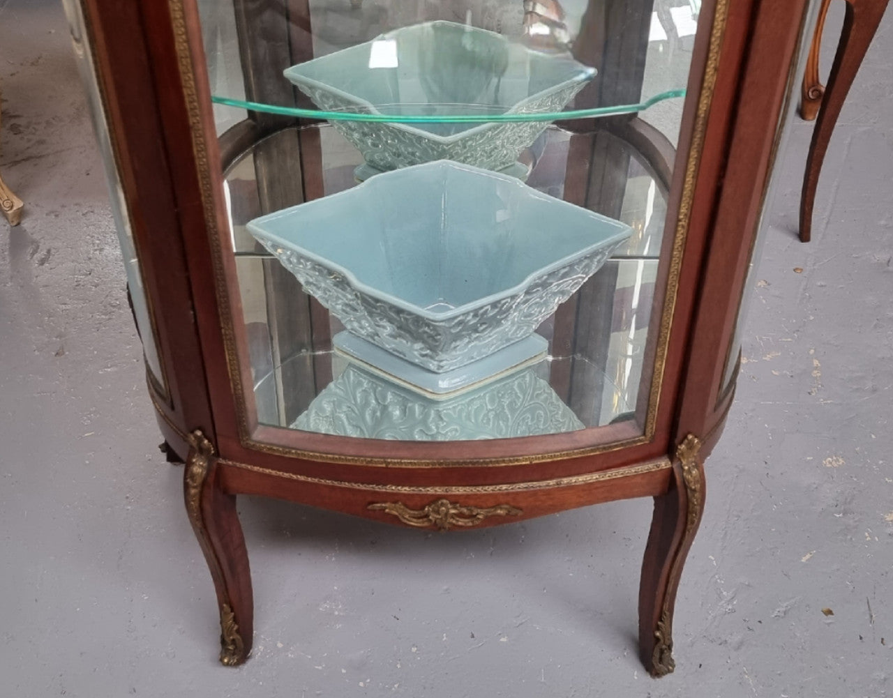 Beautiful French Louis XV style vitrine/ display cabinet with curved glass, gilt mounts, mirrored back and two glass shelves for your displays . It is in good original detailed condition.