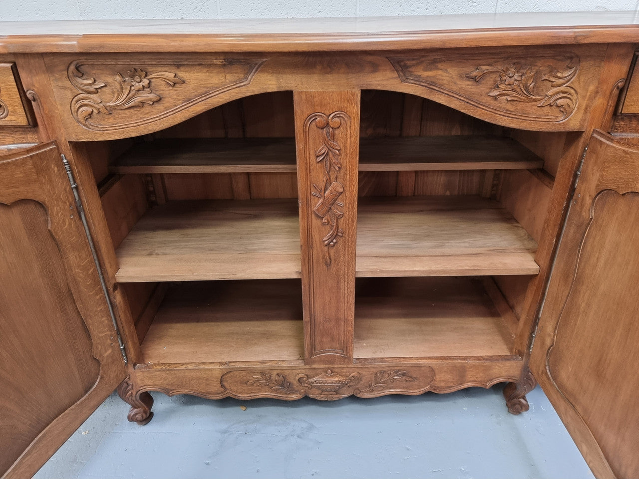 Parquetry top French oak Louis XV style sideboard with two draws and four cupboards. In good original detailed condition.