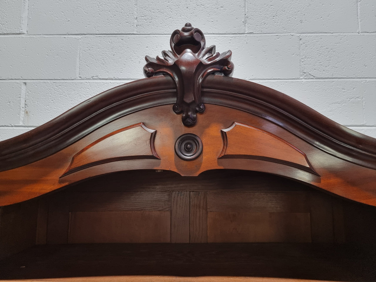 Antique Mahogany two door Biedermeier style bookcase with four fully adjustable shelves and a drawer at the bottom. The two wooden finials at the top are easily removed for a different look of desired. In good original detailed condition.