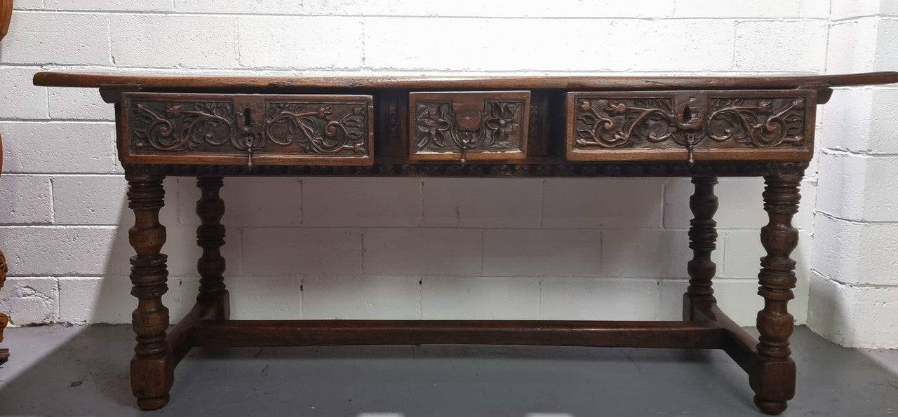 Rare and Charming 17th Century Spanish Walnut serving / side table. It has an incredible one piece walnut top with amazing character and colour. The base displays the original patina aswell as three drawers with carving and remnants of original locks. Superbly turned legs terminating on a stretcher base. Could be used as a large entrance console table, a side table or in a dining area as a serving table. In good original detailed condition especially considering its age.
