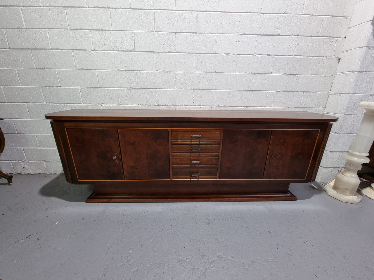 Amazing French Walnut Art deco four door buffet. The doors either side open to a fixed shelf and plenty of added storage with four drawers. In good original detailed condition.