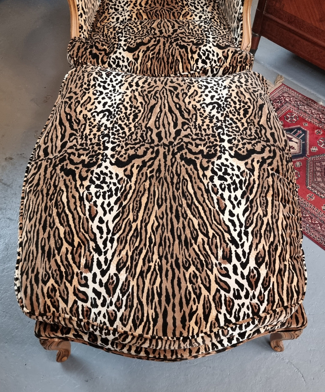 A French Louis XV style armchair with leopard print upholstery and with matched footstool. Fabric is in good original used condition. Please view photos as they help form part of the description.