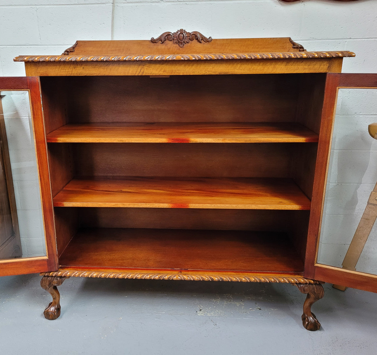 Chippendale style Mahogany two door bookcase. It has bevelled glass doors and two adjustable shelves. It has been sourced locally and is in good original detailed condition.